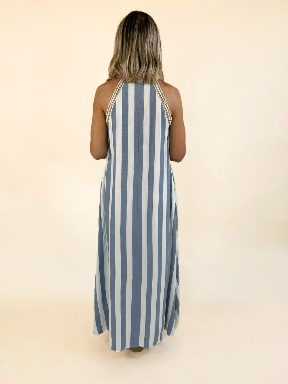 Blue and white striped halter maxi dress with a relaxed flowing fit, crochet trim neckline, and elegant full-length silhouette.