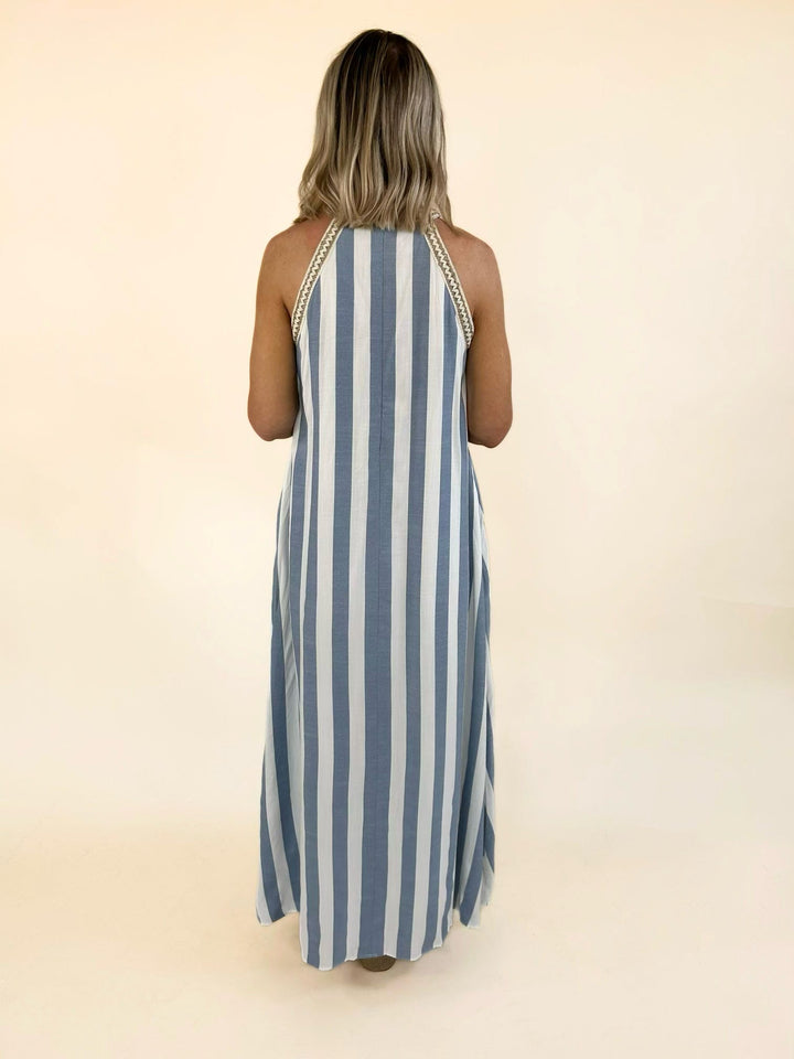 Blue and white striped halter maxi dress with a relaxed flowing fit, crochet trim neckline, and elegant full-length silhouette.