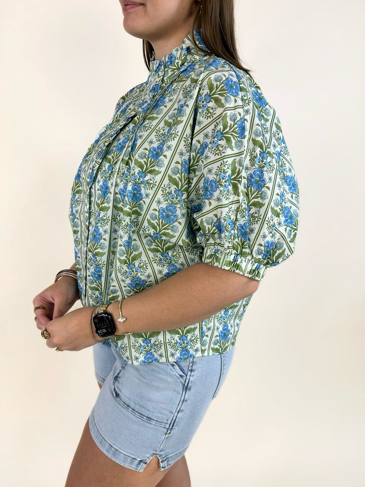 Side view of blue botanical print cotton blouse with short dolman sleeves and curved hem