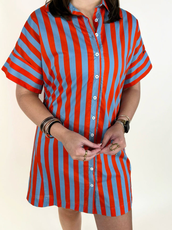 Close-up of the THML Weekend Getaway Striped Shirt Dress in blue with orange vertical stripes, showcasing the collared neckline, button-front closure, bold stripe pattern, and soft cotton fabric.