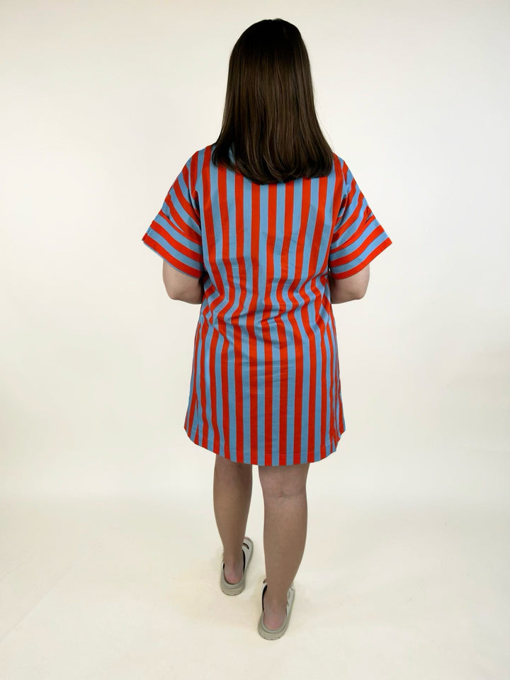 Back view of the THML Weekend Getaway Striped Shirt Dress in blue with orange vertical stripes, showcasing the relaxed shirt dress silhouette, rolled short sleeves, and breathable cotton fabric.
