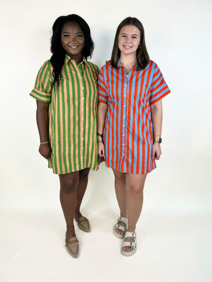Two women modeling the THML Weekend Getaway Striped Shirt Dress, available in blue with orange stripes and green with peach stripes. Features a collared neckline, button-front closure, rolled short sleeves, and relaxed mini dress silhouette.