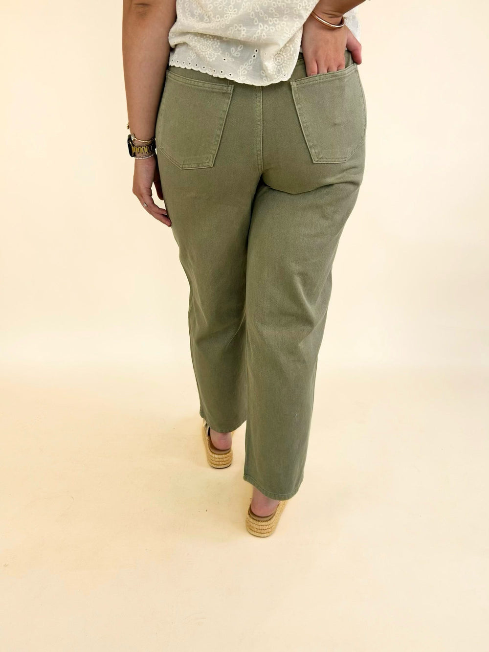 Back view of light olive wide leg jeans with a mid-rise fit, classic back pockets, and full-length wide leg silhouette.