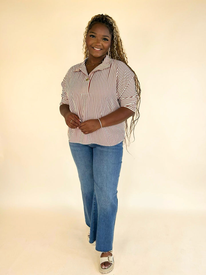Full outfit featuring a rust striped split neck blouse with rolled 3/4 sleeves, blue jeans, and sandals.