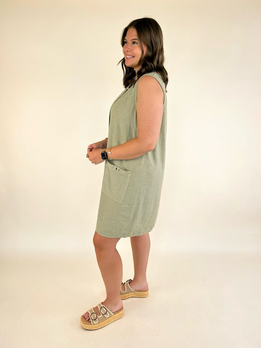 Side view of the Dear John Riri sleeveless linen blend mini dress in Abbey Stone with button-front detail and curved hem.