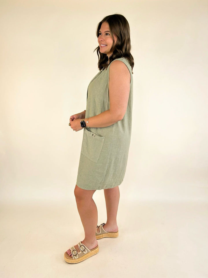 Side view of the Dear John Riri sleeveless linen blend mini dress in Abbey Stone with button-front detail and curved hem.