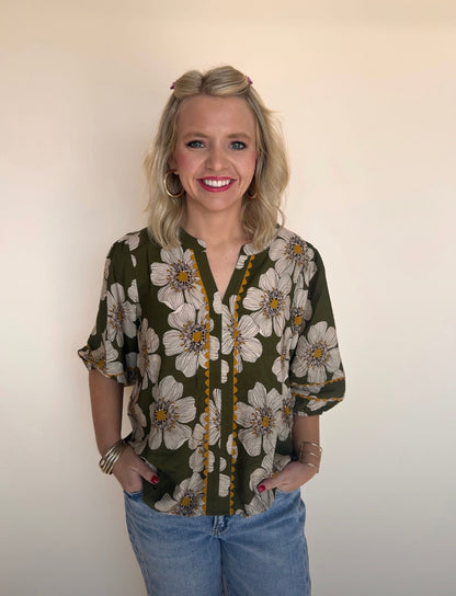 Woman wearing a floral blouse with a plain background