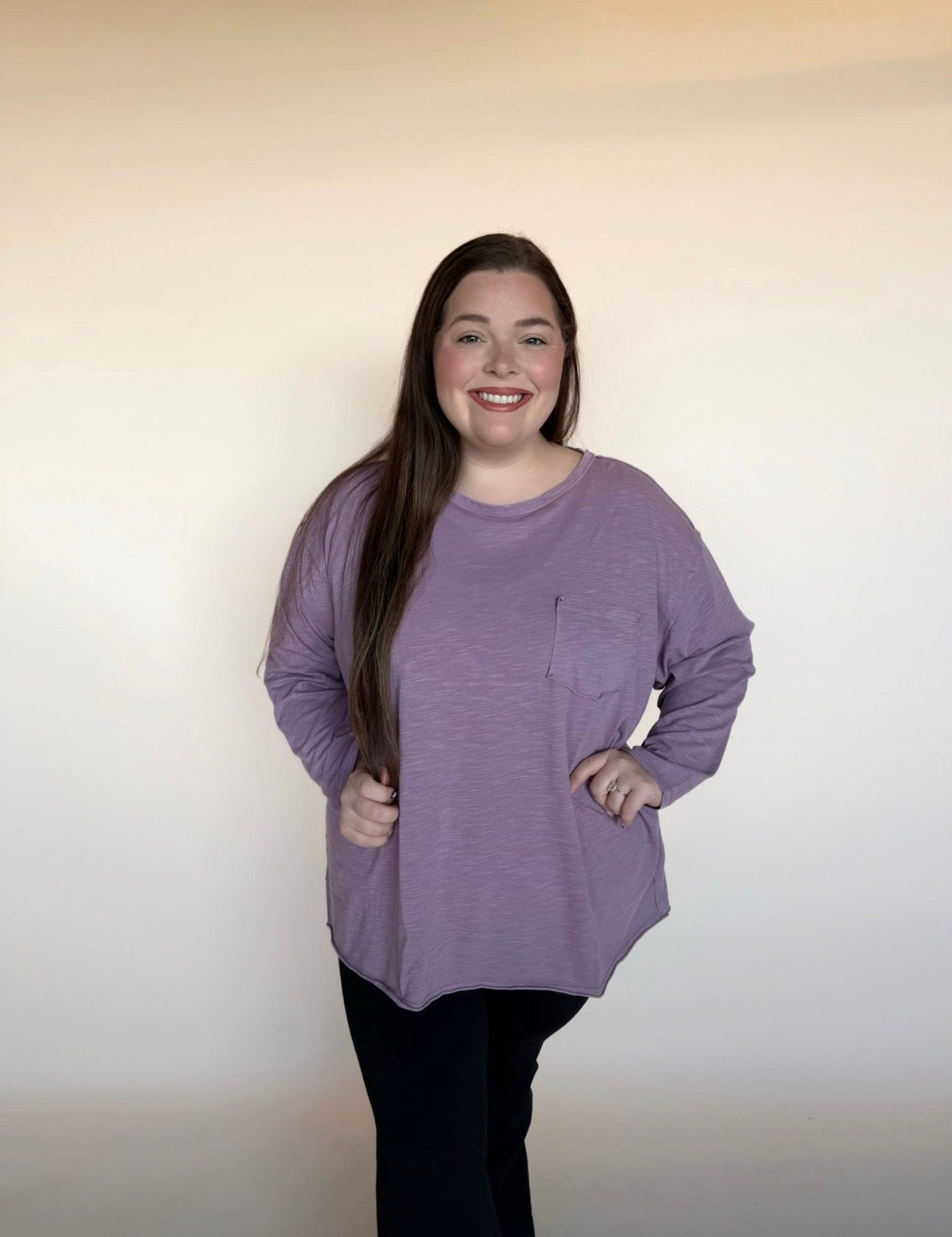 Person wearing a purple long-sleeve shirt against a plain background