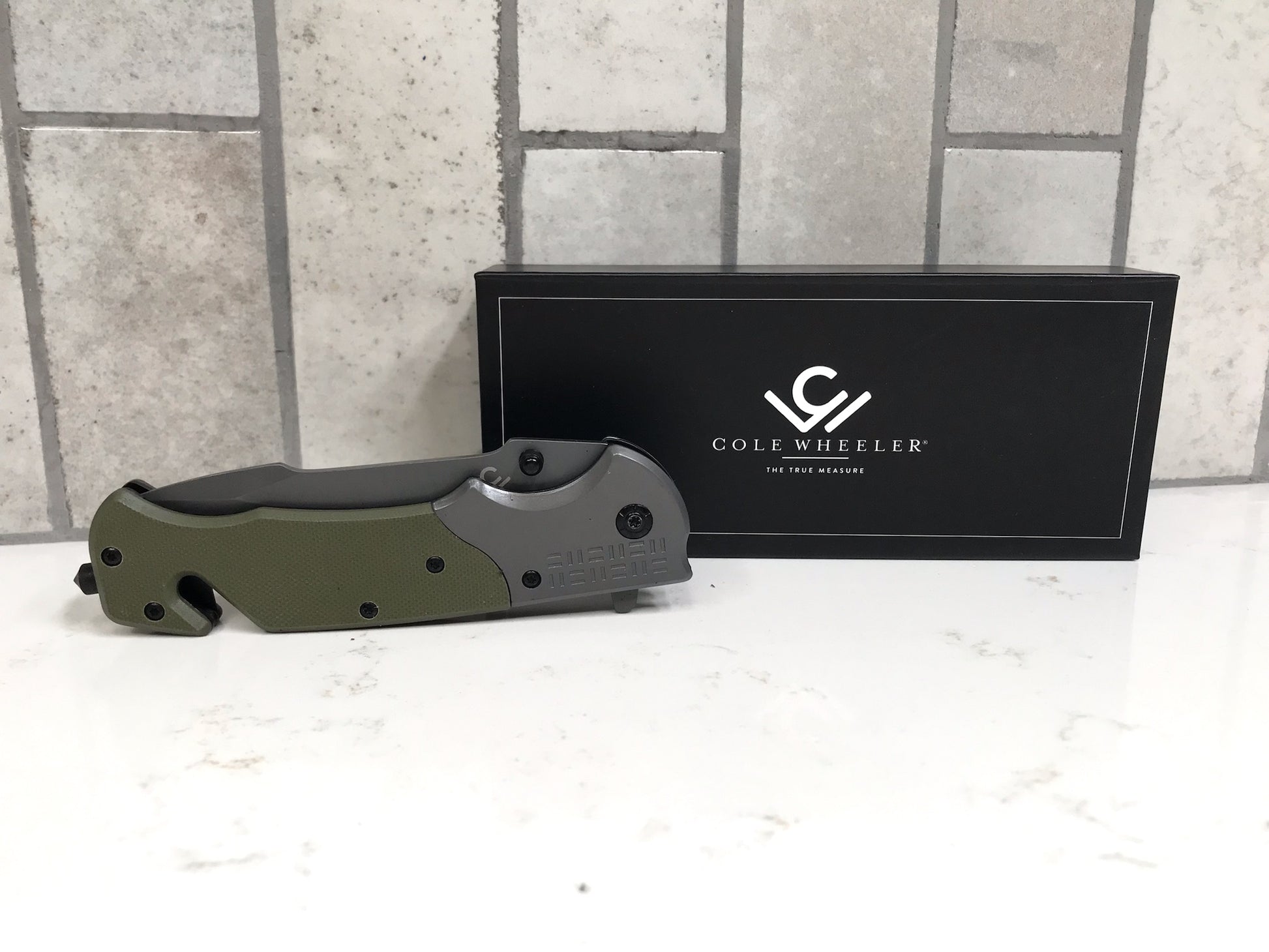 Folding knife with a black box featuring 'Cole Wheeler' logo on a light gray background.