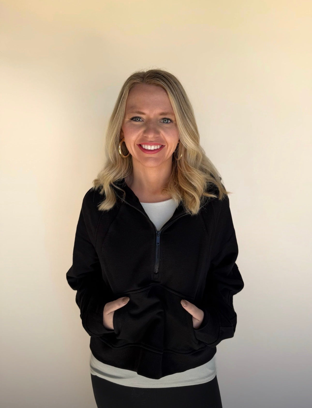 Woman wearing a black jacket with a plain background