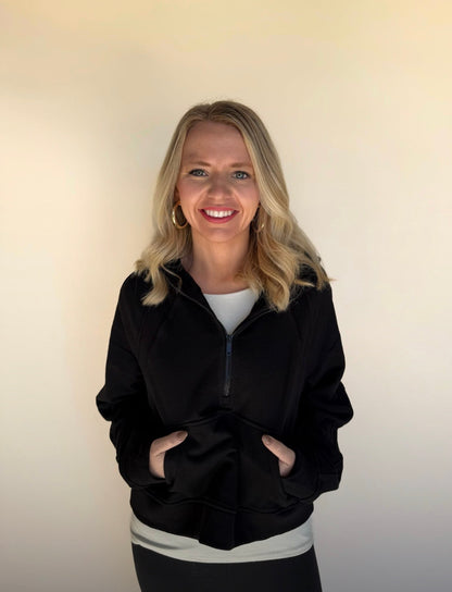 Woman wearing a black jacket with a plain background