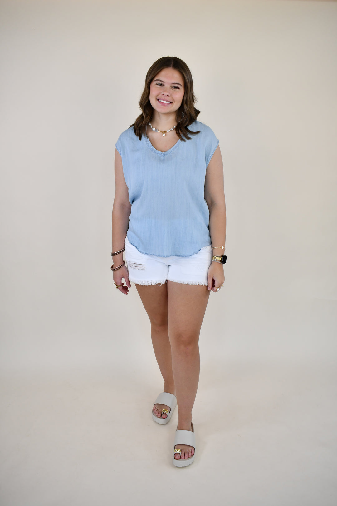 Woman wearing the Dear John Yanis V-Neck Cap Sleeve Top in Skyway Light Wash featuring a relaxed fit, V-neckline, and cap sleeves.
