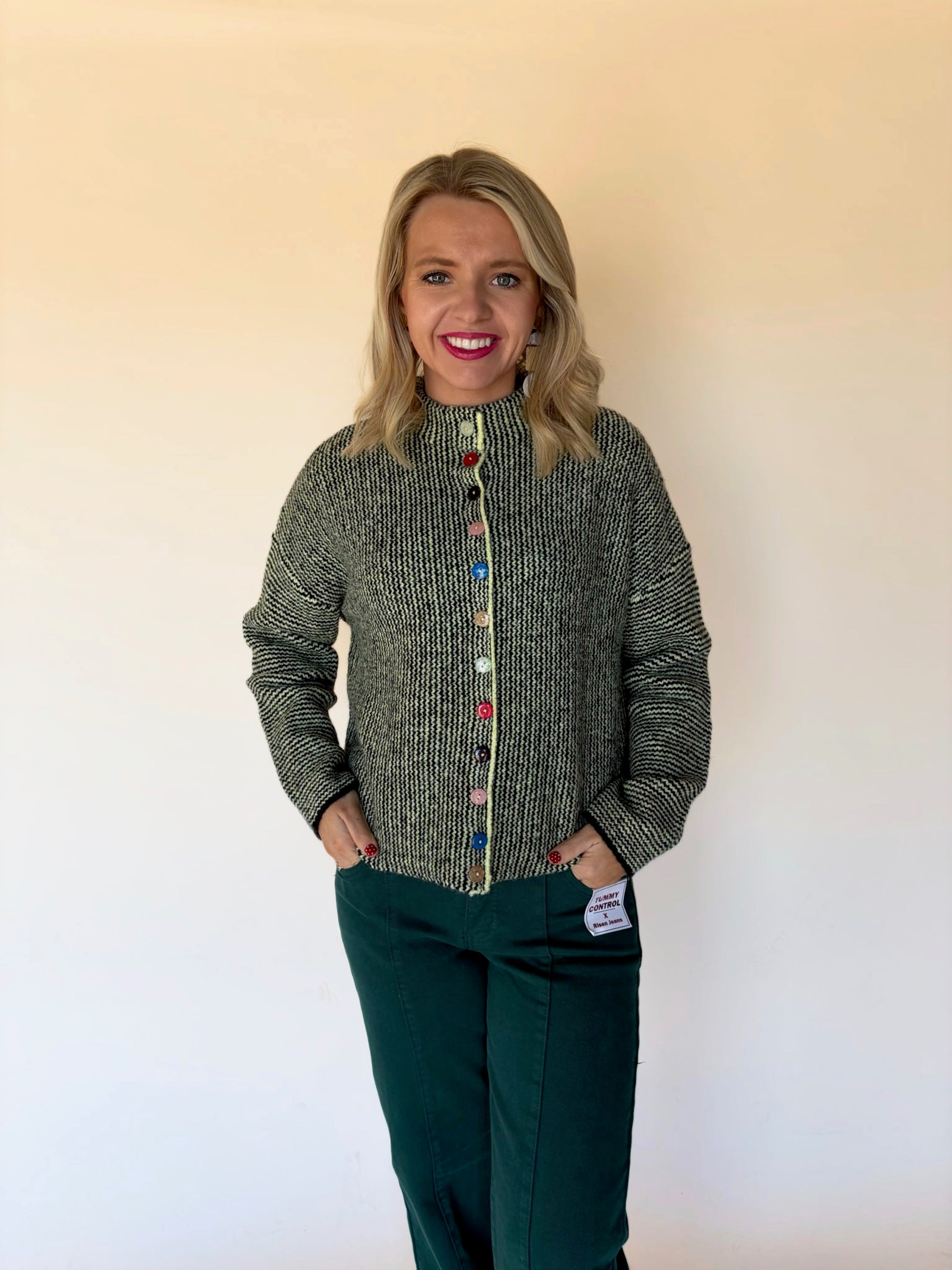 Green knit cardigan with colorful button front worn by model, women’s boutique sweater at Square 1 Boutique