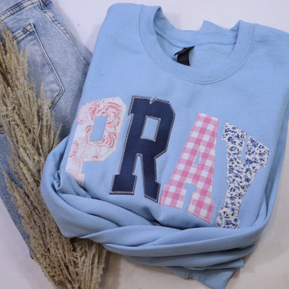 Light blue sweatshirt with decorative letters on a white background