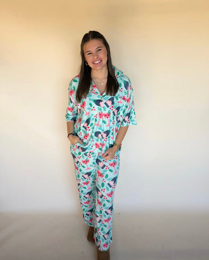 Woman wearing a holiday pajama set against a plain background
