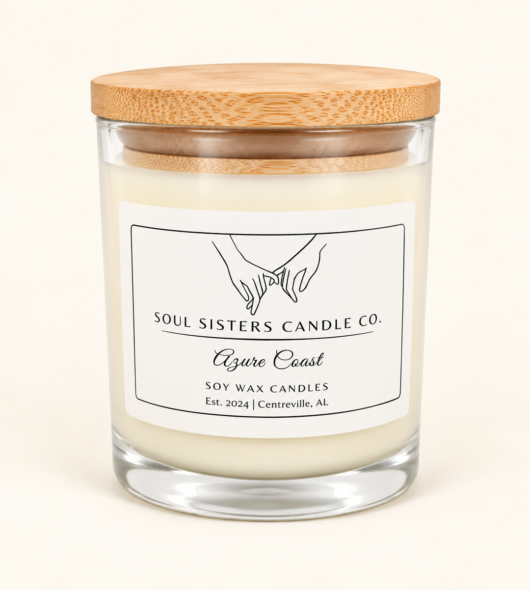 Soul Sisters Candle Co. Azure Coast scented soy wax candle in a clear glass jar with natural bamboo lid and minimalist white label on a cream background.