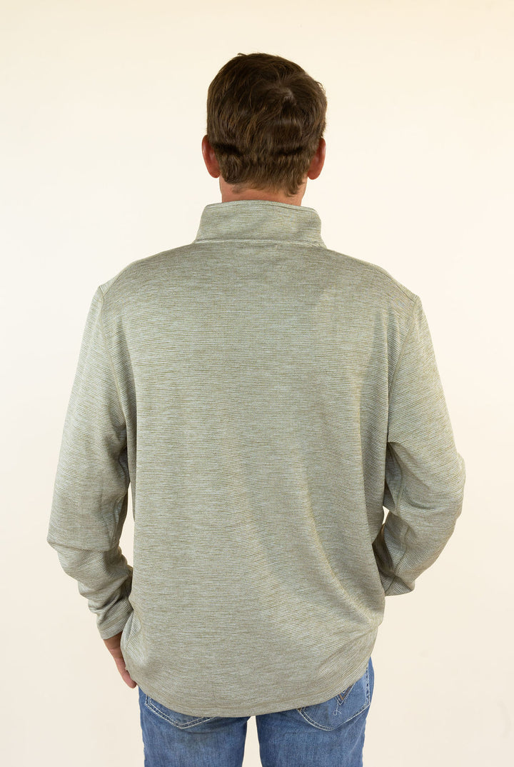 A man viewed from behind wearing a light heather olive long-sleeve quarter-zip pullover and blue jeans, standing against a plain off-white background.