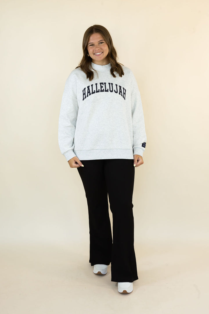 A woman modeling a light gray mockneck sweatshirt with &