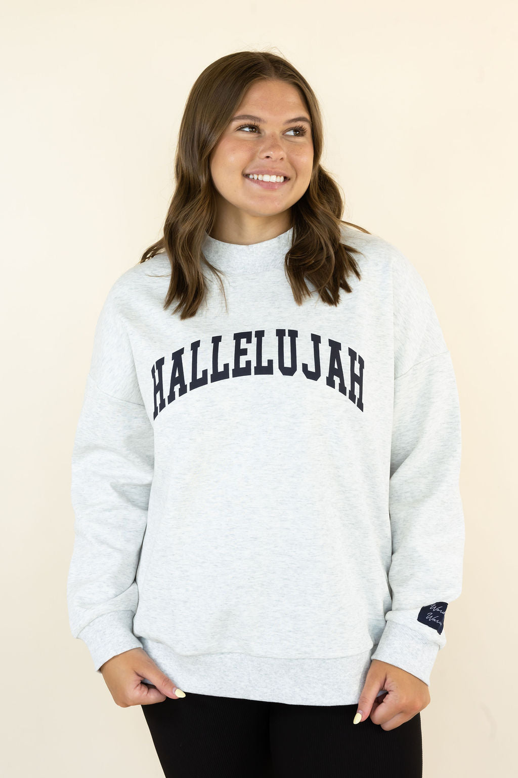 A woman wearing a light heather gray sweatshirt with &
