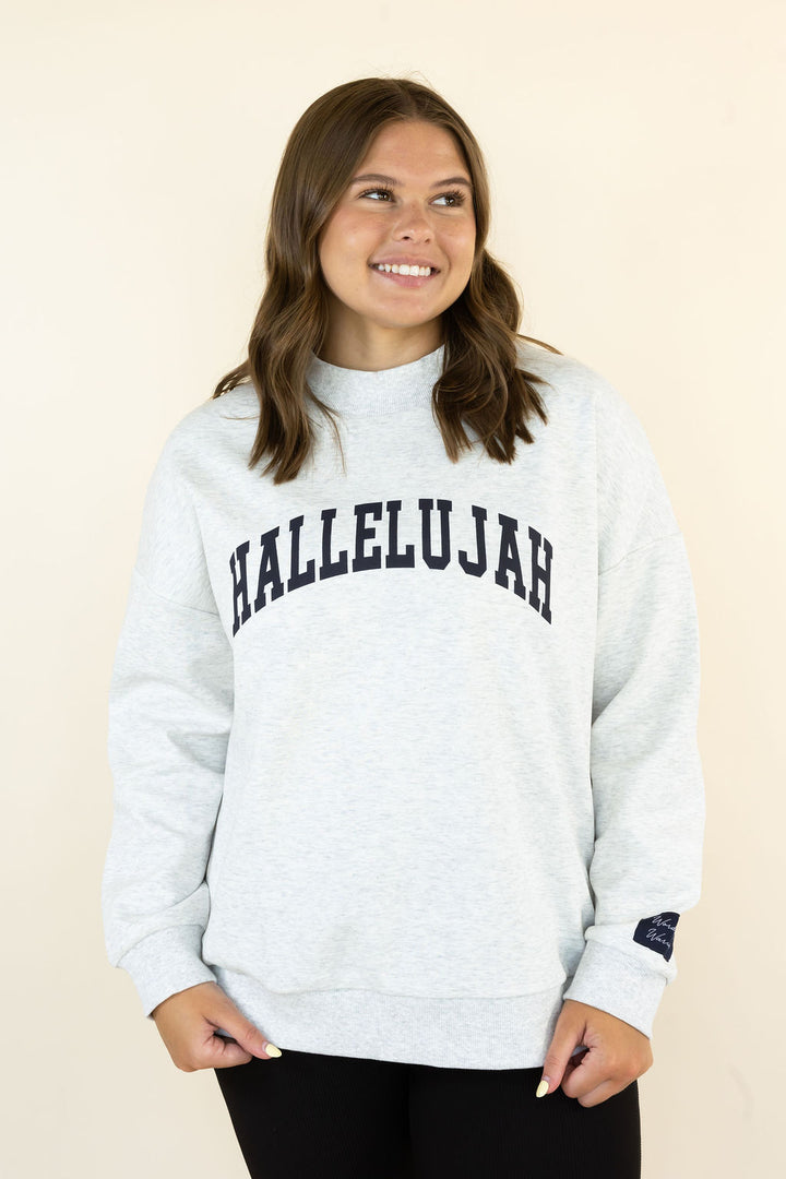 A woman wearing a light heather gray sweatshirt with &
