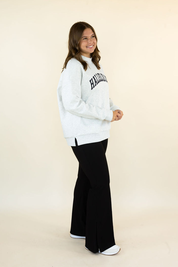 A woman modeling a light gray sweatshirt with &