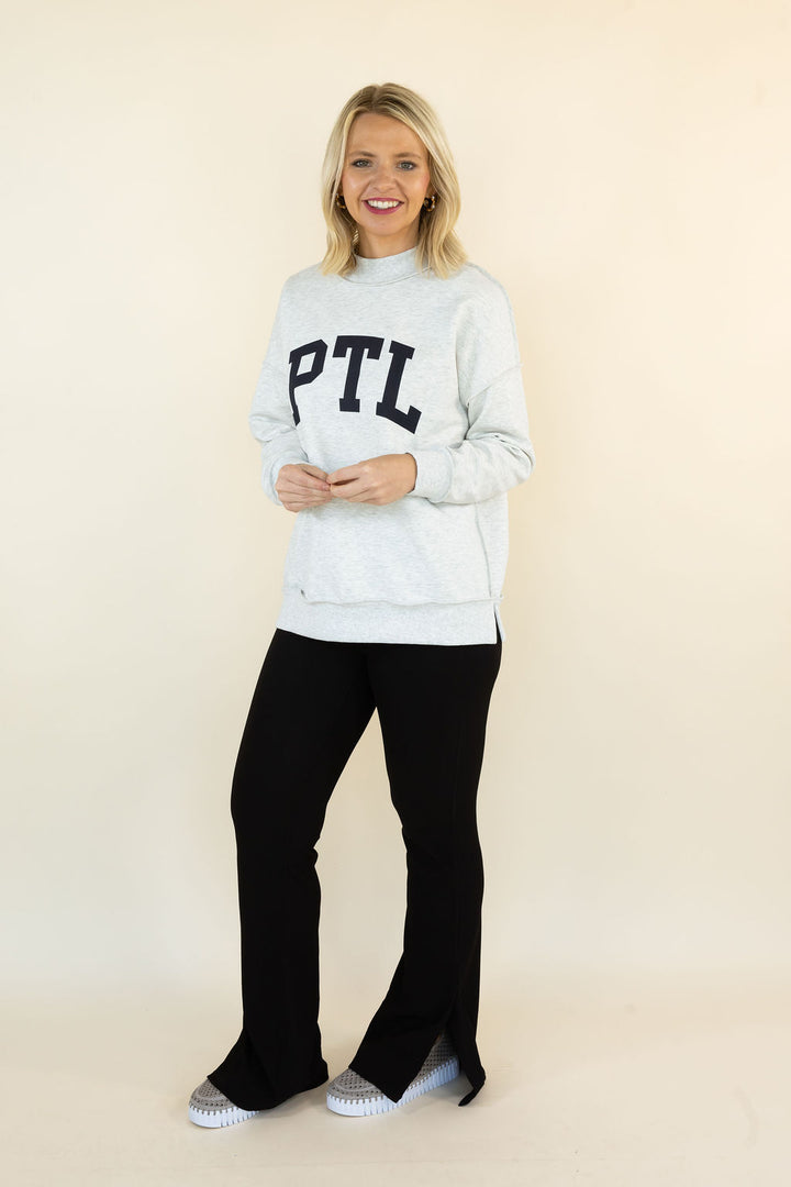A woman modeling a light gray sweatshirt with &