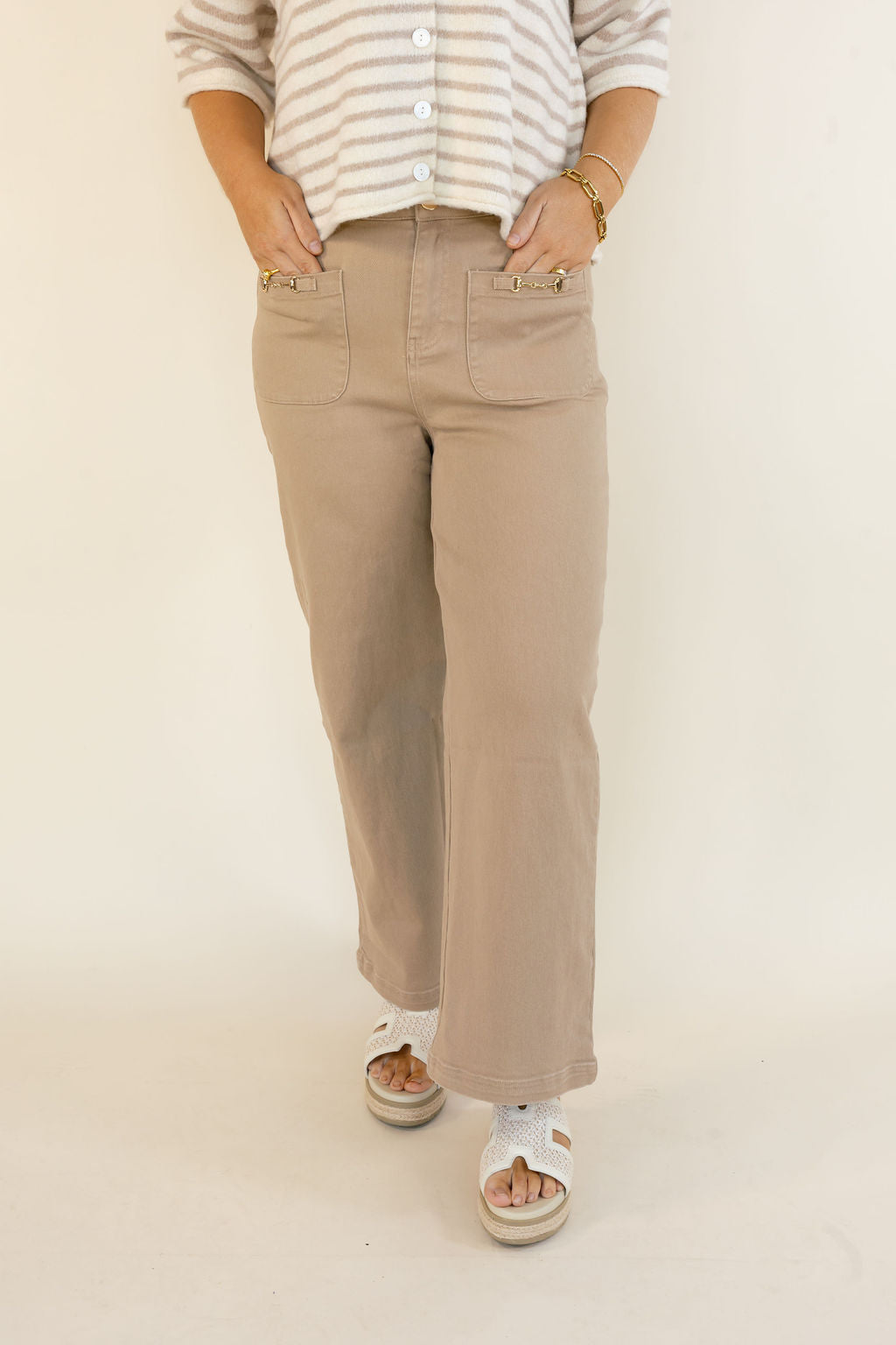 Front view of taupe cropped wide leg pants featuring high-rise waist, front patch pockets, and relaxed leg styled with a striped top