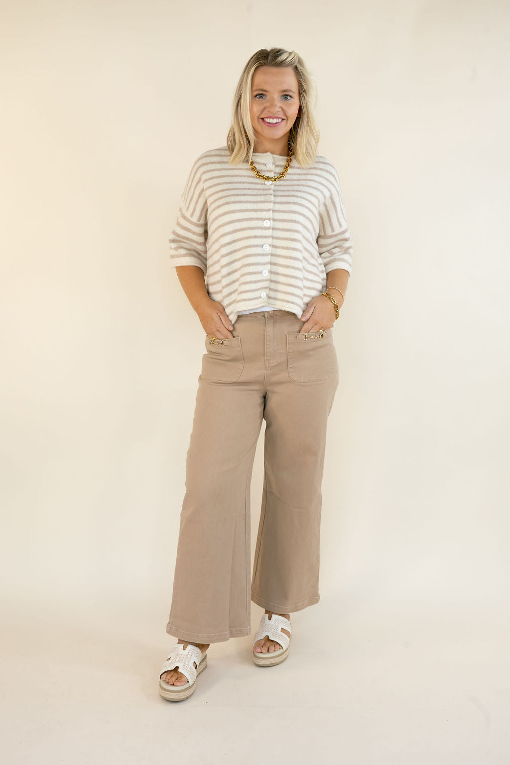 Woman modeling taupe cropped wide leg pants with front patch pockets and relaxed fit styled with a striped short sleeve top and sandals
