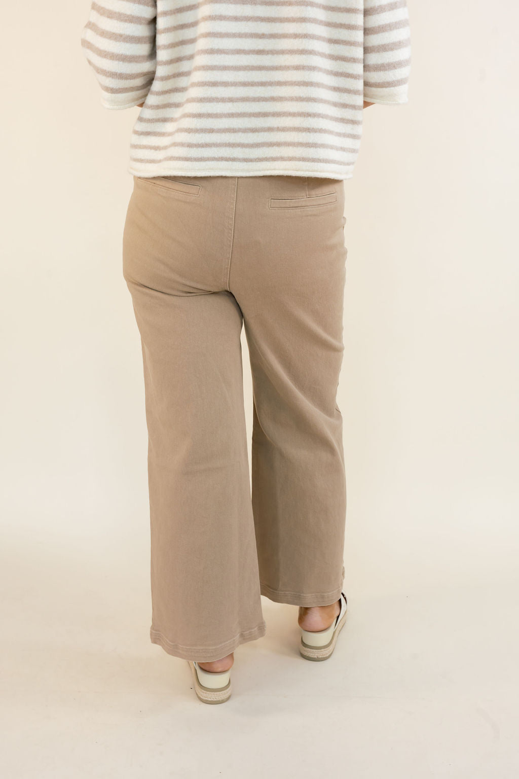 Back view of taupe cropped wide leg pants showing the relaxed silhouette, wide legs, and ankle-length hem