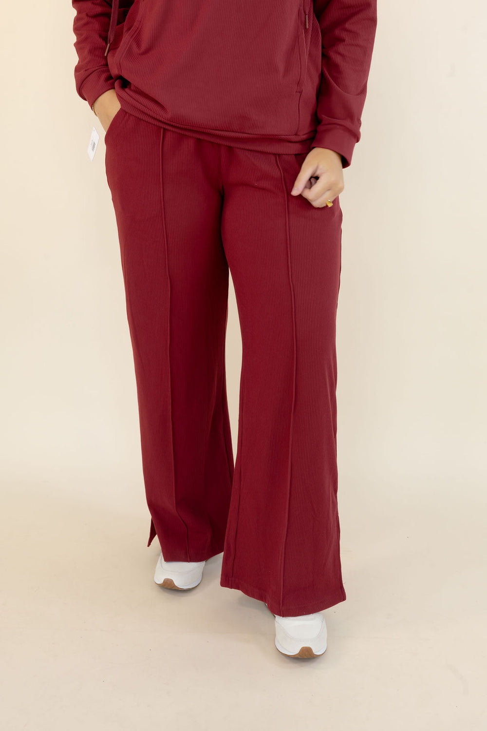 Front view of deep red wide leg pants featuring relaxed fit, full-length silhouette, and side pockets
