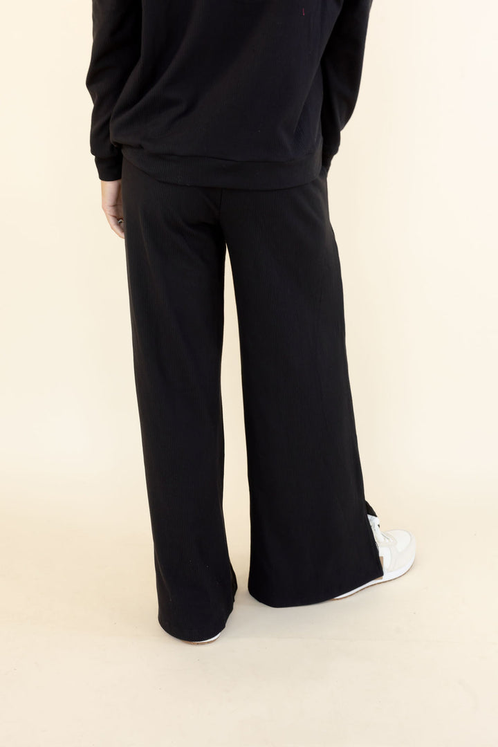 Back view of black wide leg pants showing full-length relaxed legs and flowing silhouette