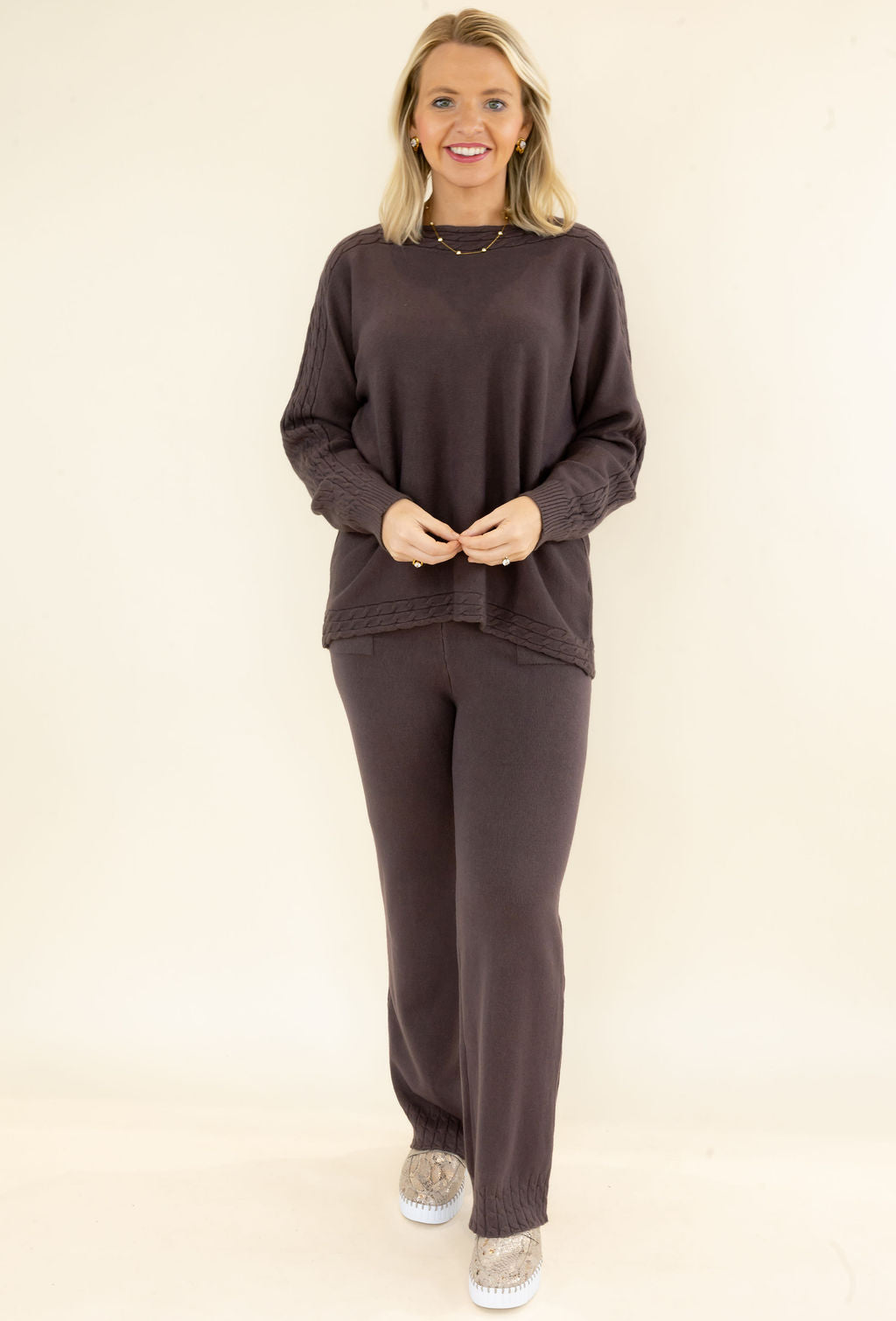 Woman modeling chocolate brown matching knit lounge set with long sleeve textured pullover and relaxed wide leg pants styled with casual sneakers