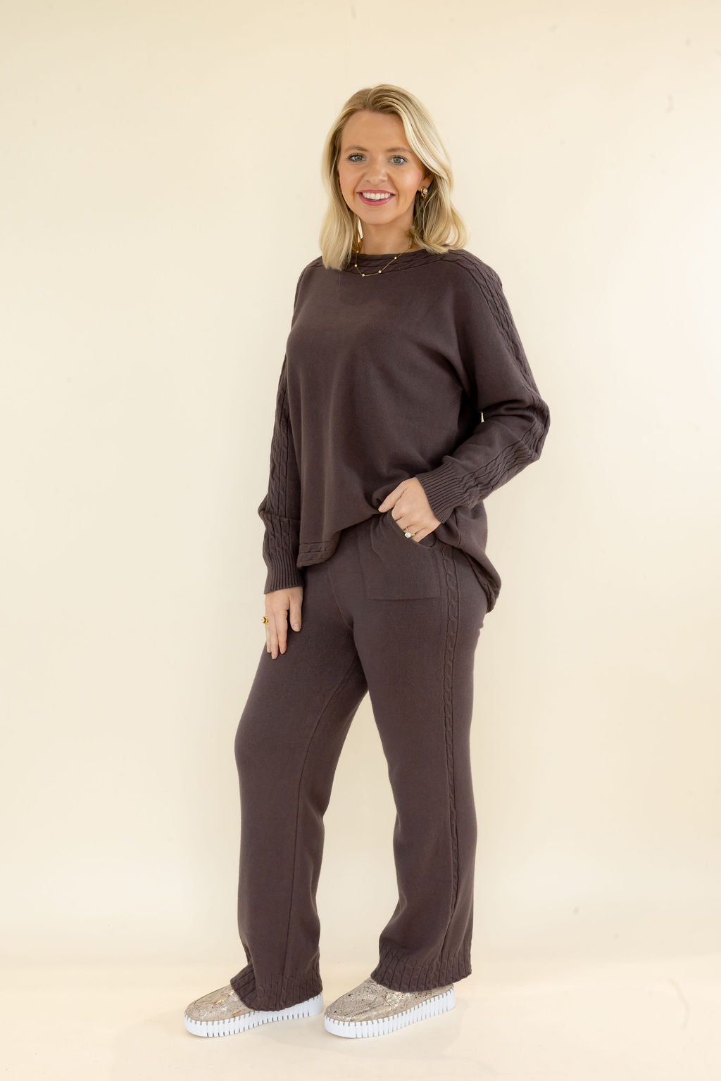 Three-quarter view of woman wearing chocolate brown matching knit lounge set with relaxed pullover and wide leg pants