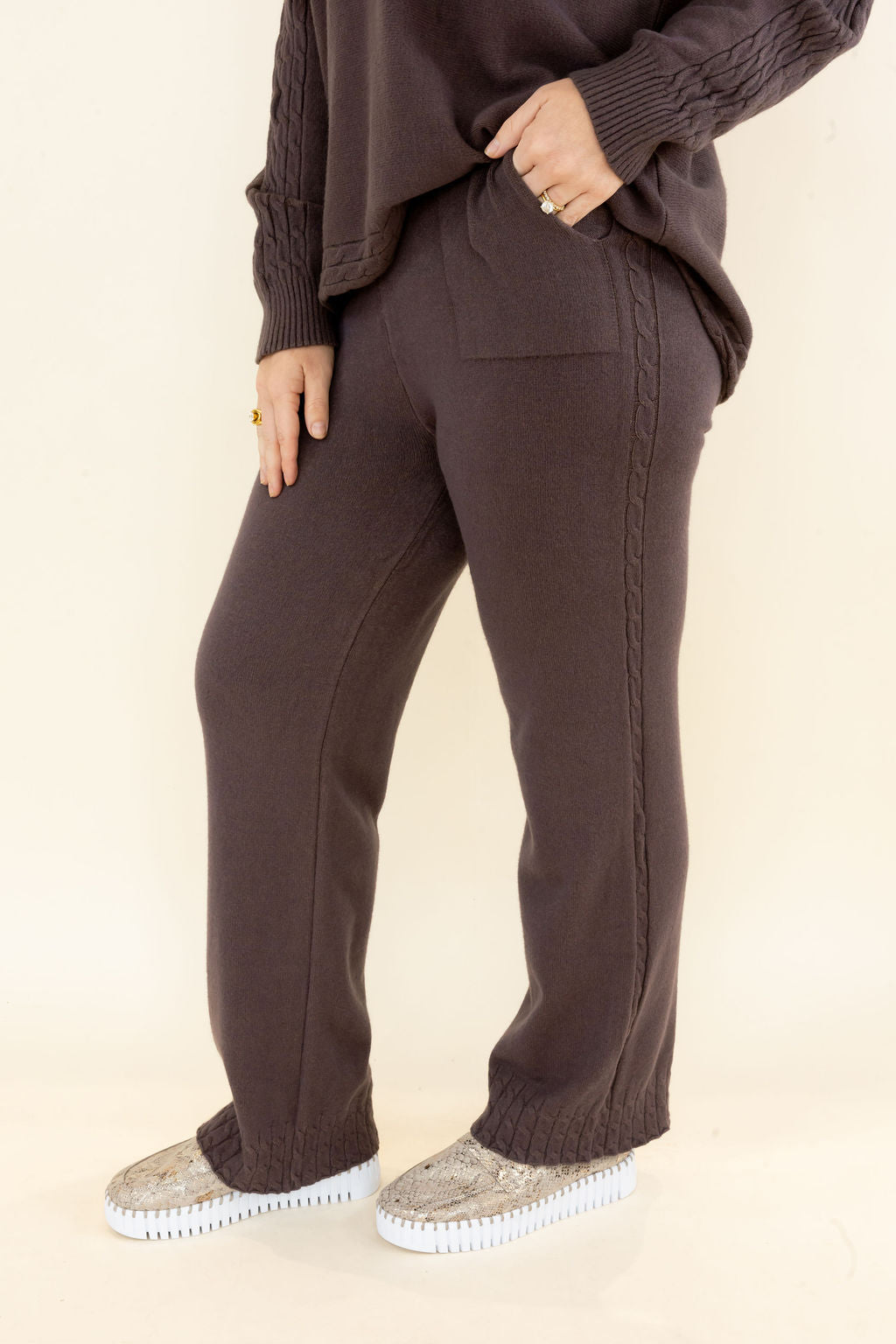 Front view of chocolate brown knit wide leg pants showing elastic waistband, side pockets, textured fabric, and relaxed fit. 