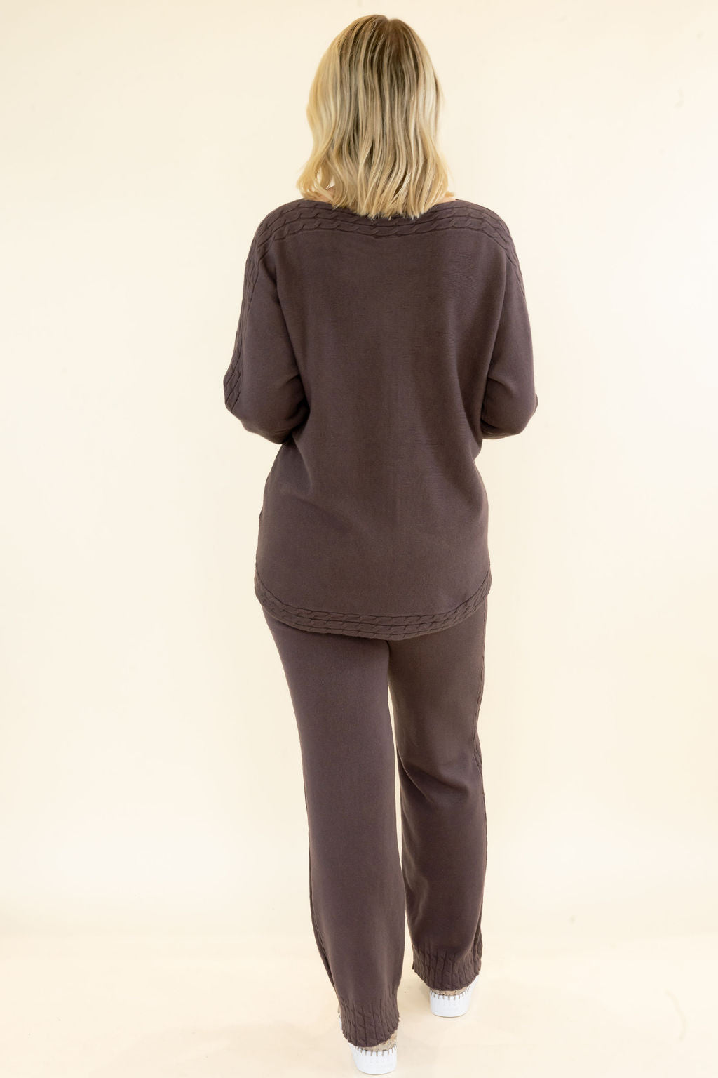 Back view of woman wearing chocolate brown matching knit set with relaxed long sleeve pullover and coordinating wide leg pants