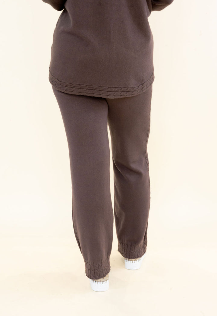 Back view of chocolate brown knit lounge pants showing elastic waistband, relaxed fit, and full-length wide leg silhouette