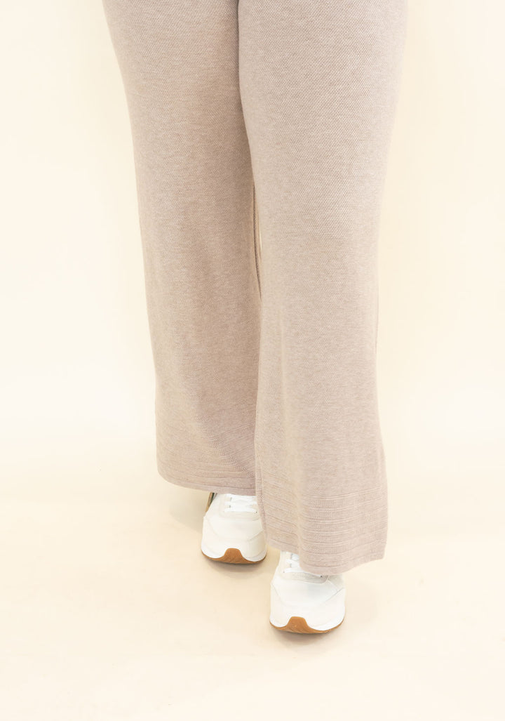 Front view of light taupe knit wide leg pants showing soft textured fabric, relaxed silhouette, and full-length wide legs