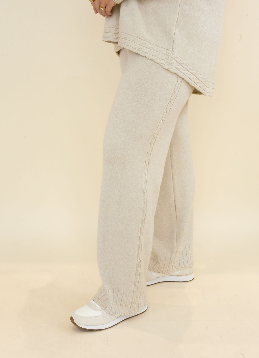 Side view of light oatmeal wide leg knit pants featuring relaxed drape, full-length leg, and coordinating textured fabric