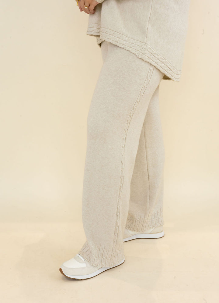 Side view of light oatmeal wide leg knit pants featuring relaxed drape, full-length leg, and coordinating textured fabric