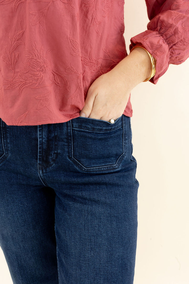 Close-up of dark wash jeans highlighting the waistband, front pocket, dark indigo wash, and subtle fading