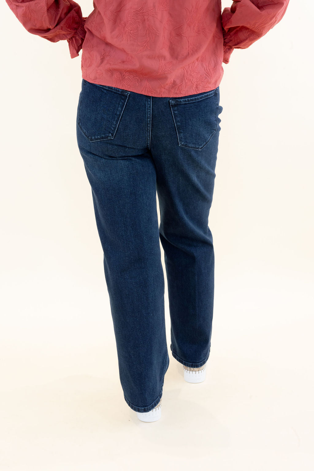 Back view of dark wash wide leg jeans showing back patch pockets, flattering fit through the hips, and relaxed wide legs