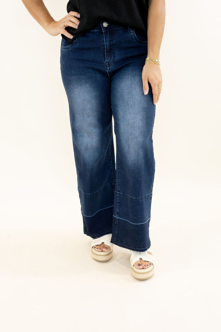 Front view of EverStretch indigo dark denim wide leg jeans showing button closure, front pockets, faded wash, cropped length, and release hem