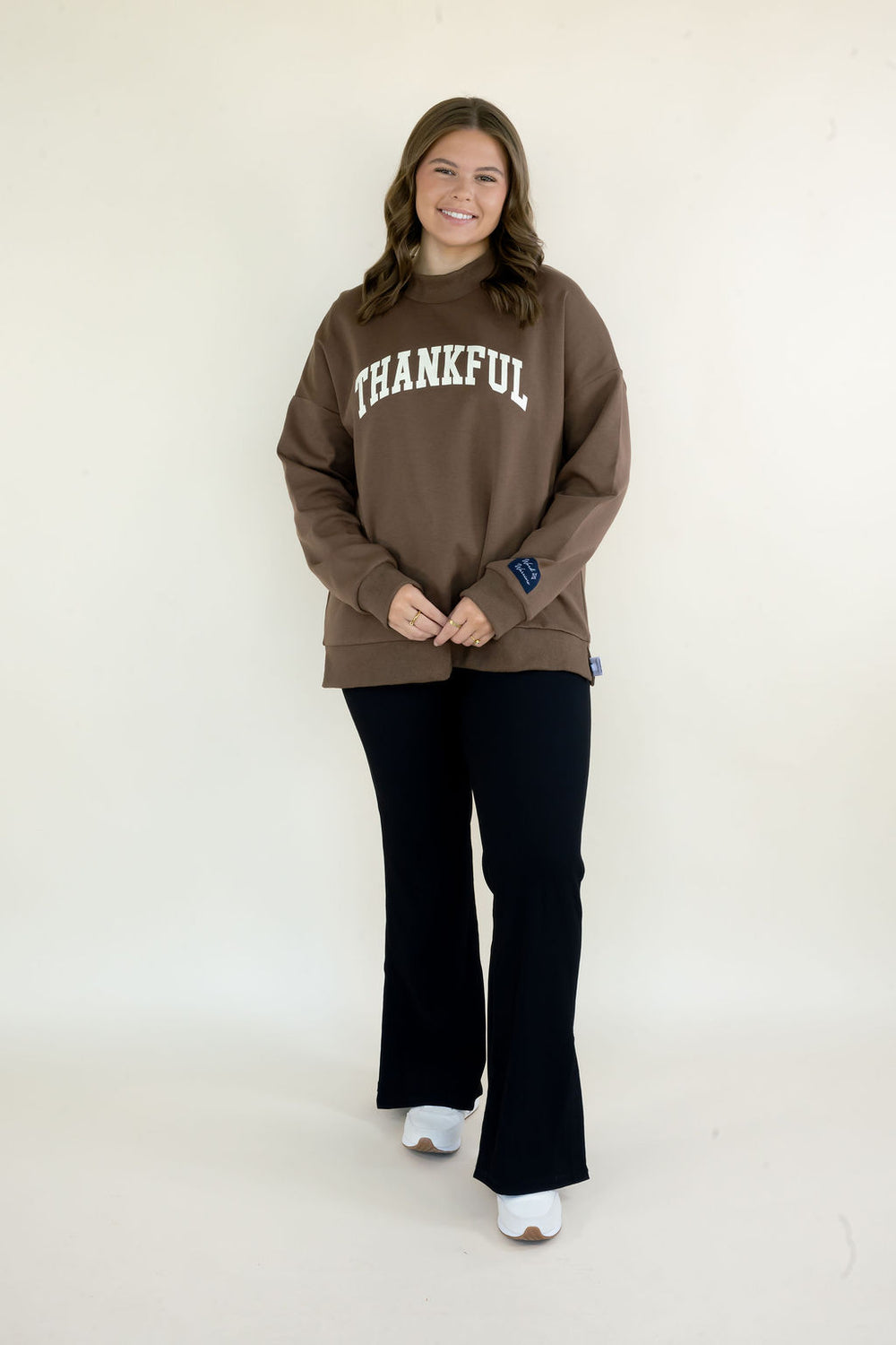 Woman modeling brown Reversible Thankful & Blessed Mockneck Sweatshirt with Thankful graphic, mock neckline, relaxed fit, and black pants