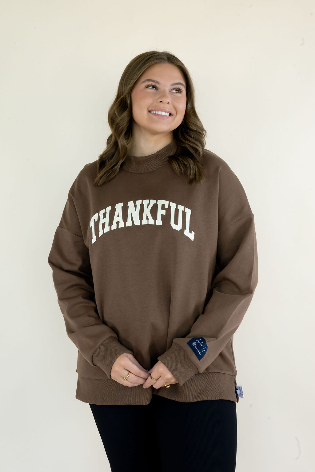 Front view of brown reversible mockneck sweatshirt featuring white Thankful lettering, relaxed silhouette, and ribbed hem