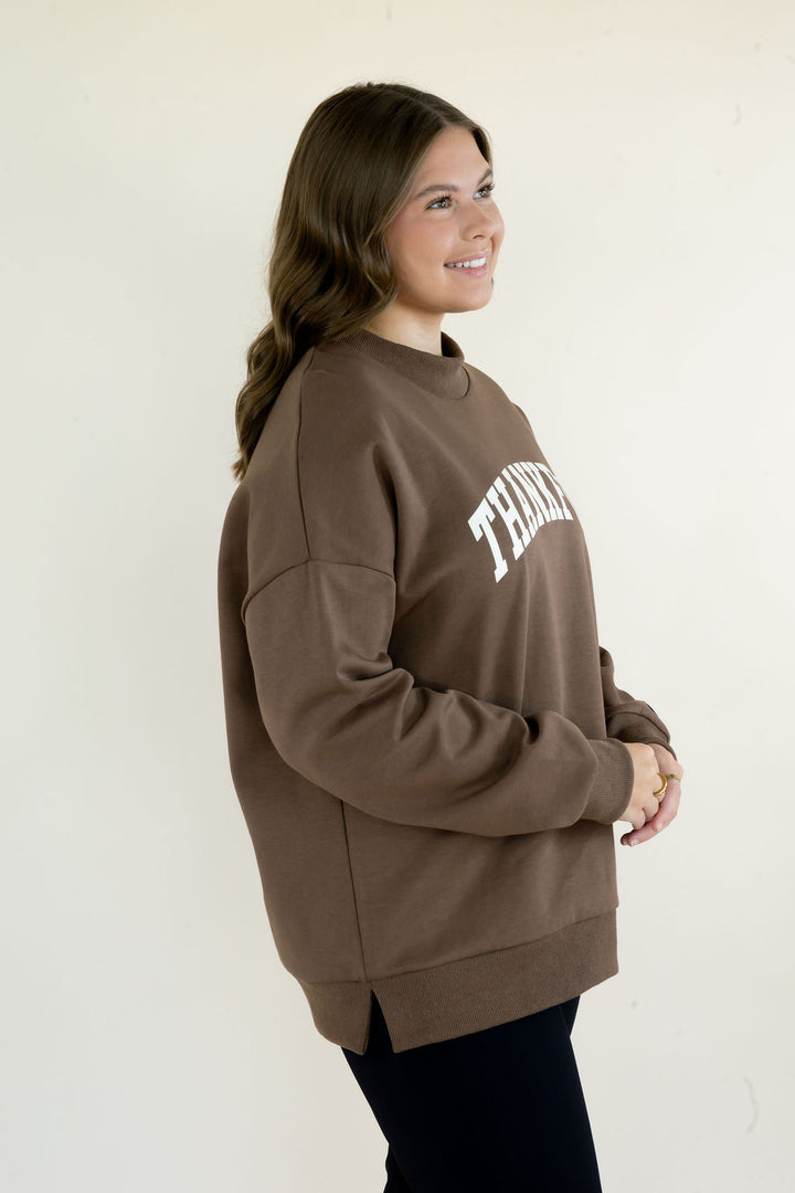 Three-quarter view of brown Reversible Thankful &amp; Blessed Mockneck Sweatshirt worn with the Thankful graphic facing front