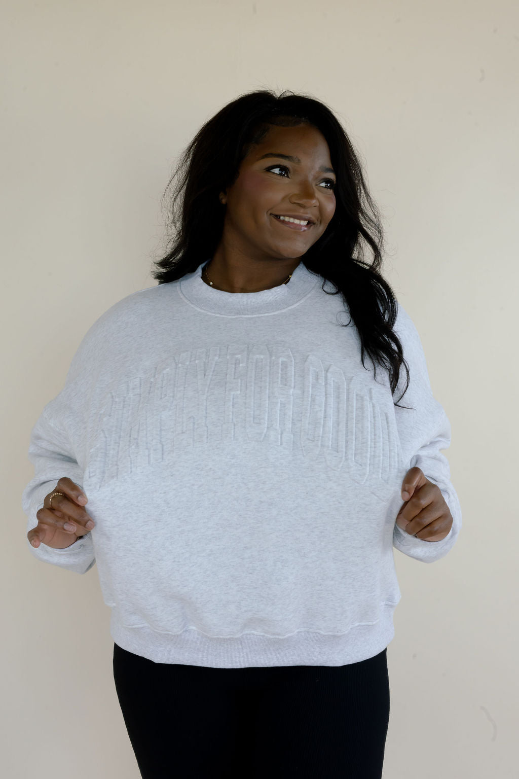 Woman modeling heather gray Simply For Good crewneck sweatshirt with tonal raised lettering, long sleeves, and relaxed fit