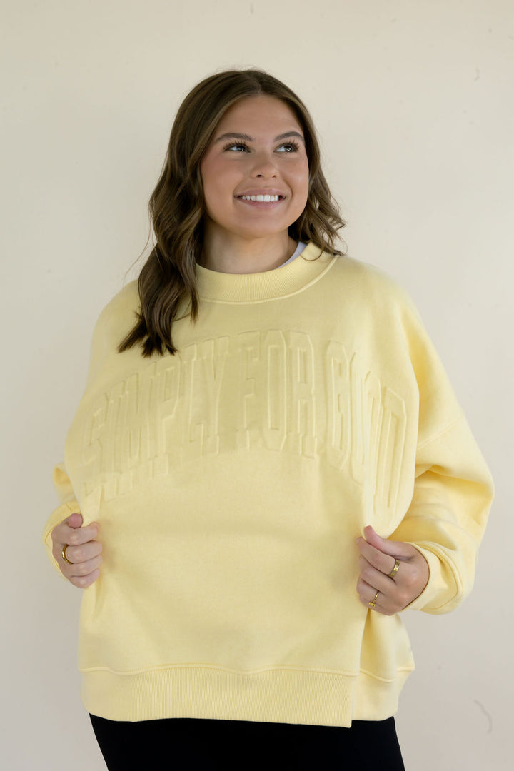 Front view of butter yellow Simply For Good crewneck sweatshirt highlighting tonal lettering, long sleeves, and relaxed silhouette