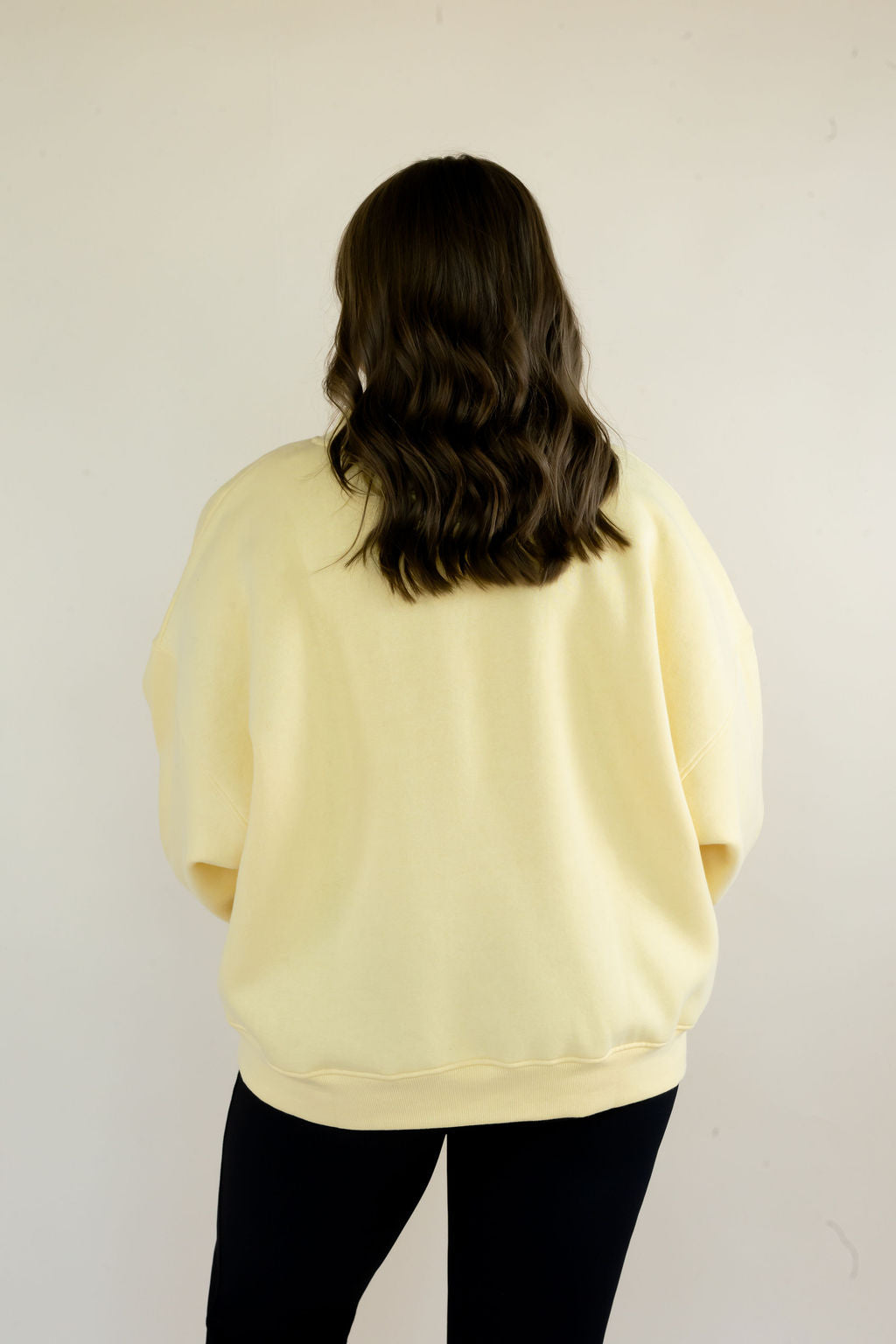 Back view of butter yellow Simply For Good crewneck sweatshirt showing relaxed fit and small Simply For Good back neck detail