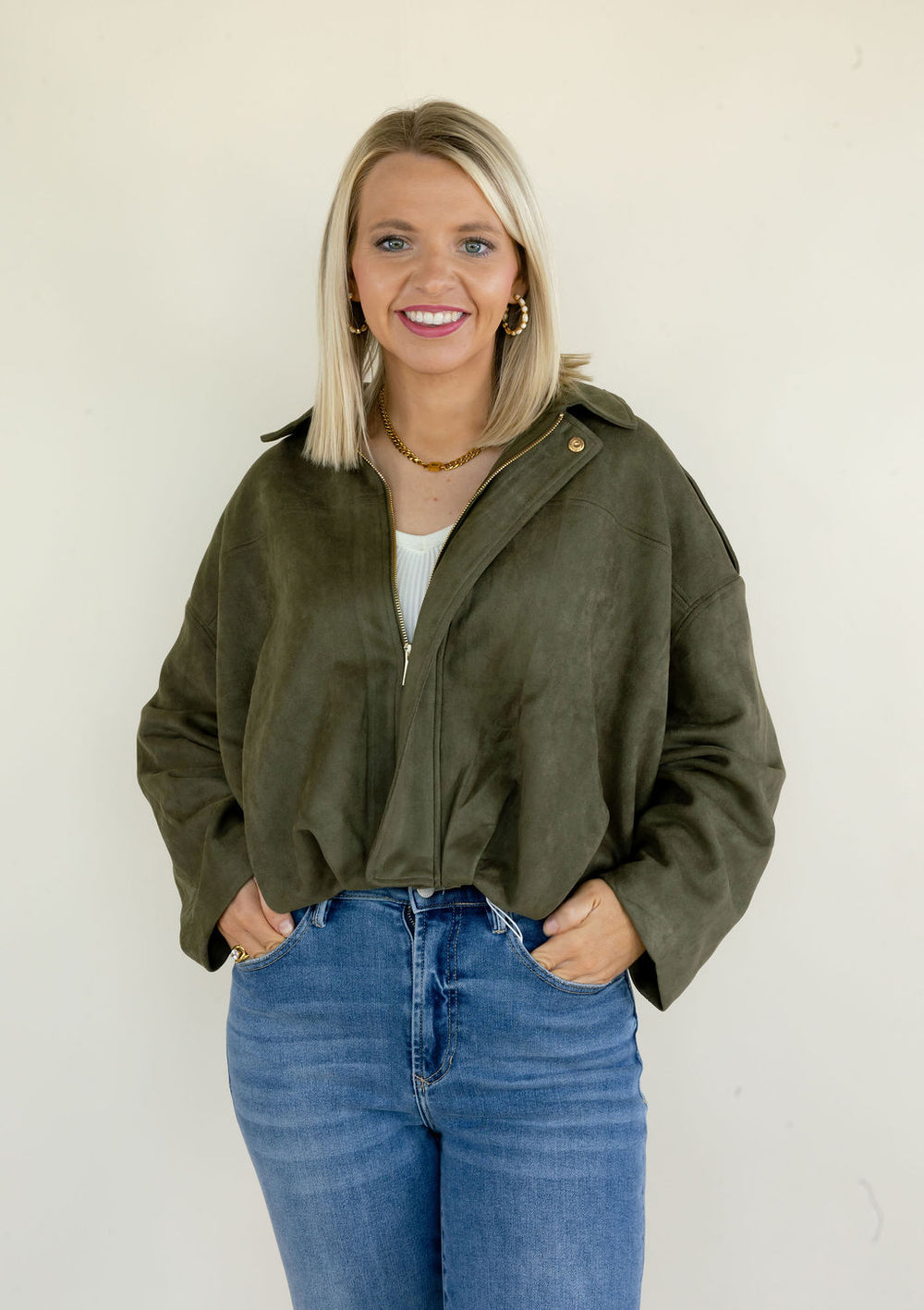 Front view of woman wearing olive green full zip jacket featuring a collared neckline, relaxed fit, long sleeves, and cropped hem