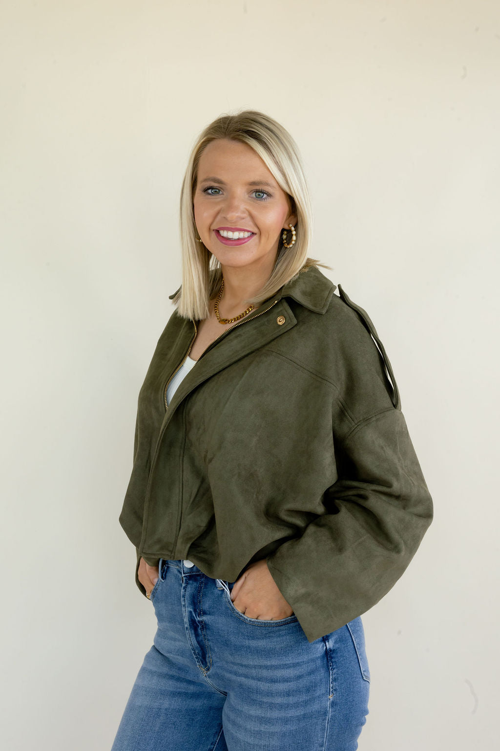 Three-quarter view of olive green full zip jacket showing the collared neckline, zip front, relaxed sleeves, and casual oversized silhouette